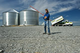 A man looks outwards as grain is stored in the background